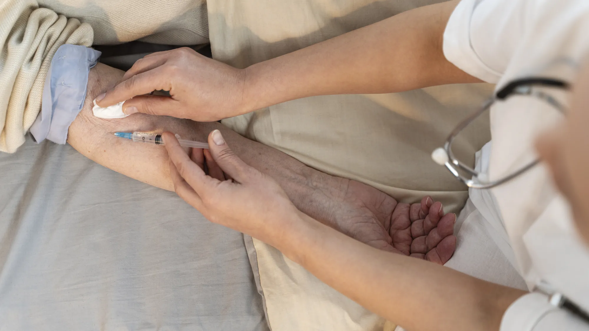 Giving an injection into the upper arm of an elderly patient