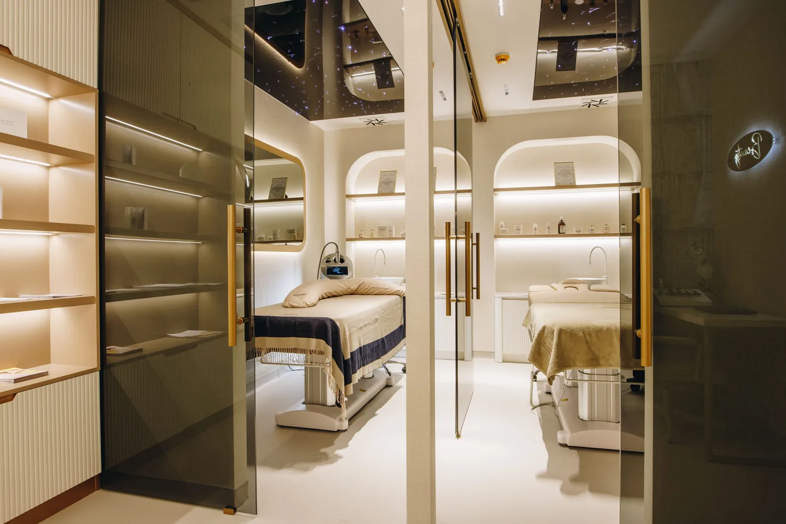 Interior of a modern treatment room at the Miren Medic clinic with luxury treatment beds, warm lighting and elegant glass partitions.