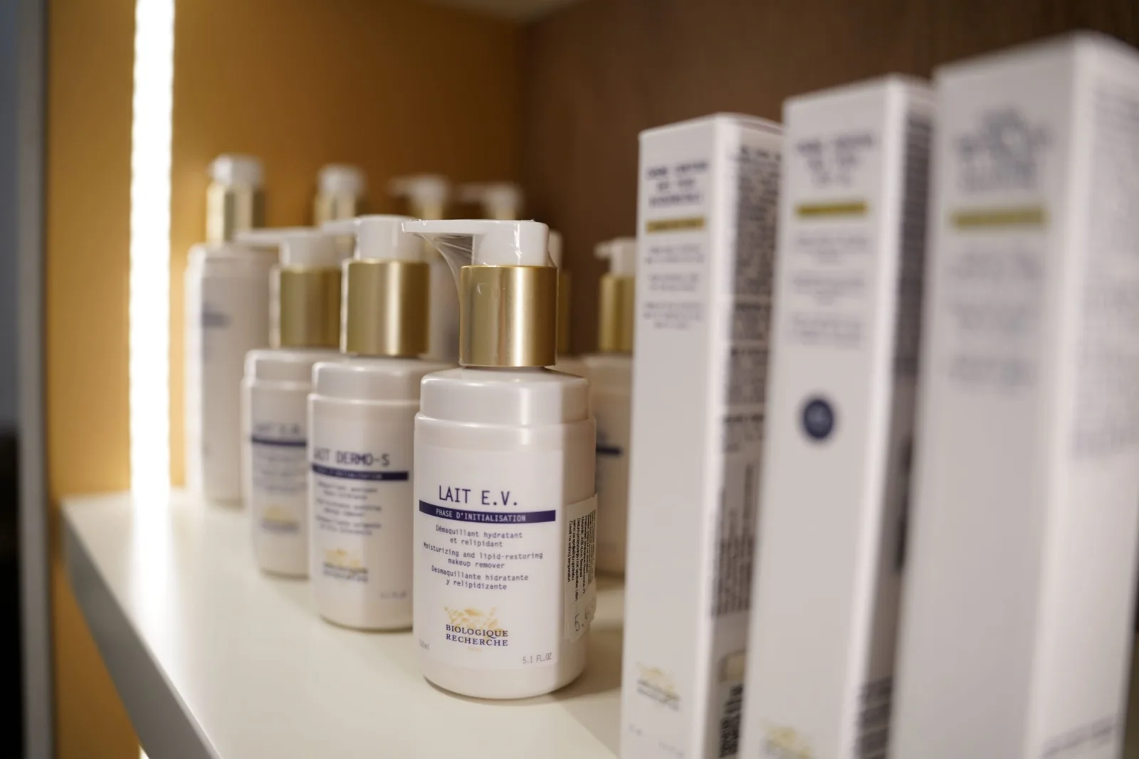 Close up of Biologique Recherche Lait E.V. cleansing milk on a lit shelf at the Miren Medic clinic.