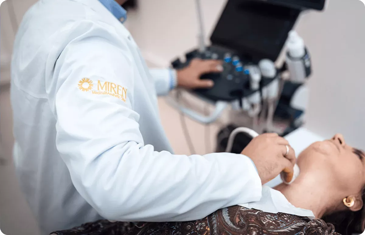 A doctor at Miren Polyclinic performing a neck ultrasound examination on a patient, a private polyclinic in Belgrade