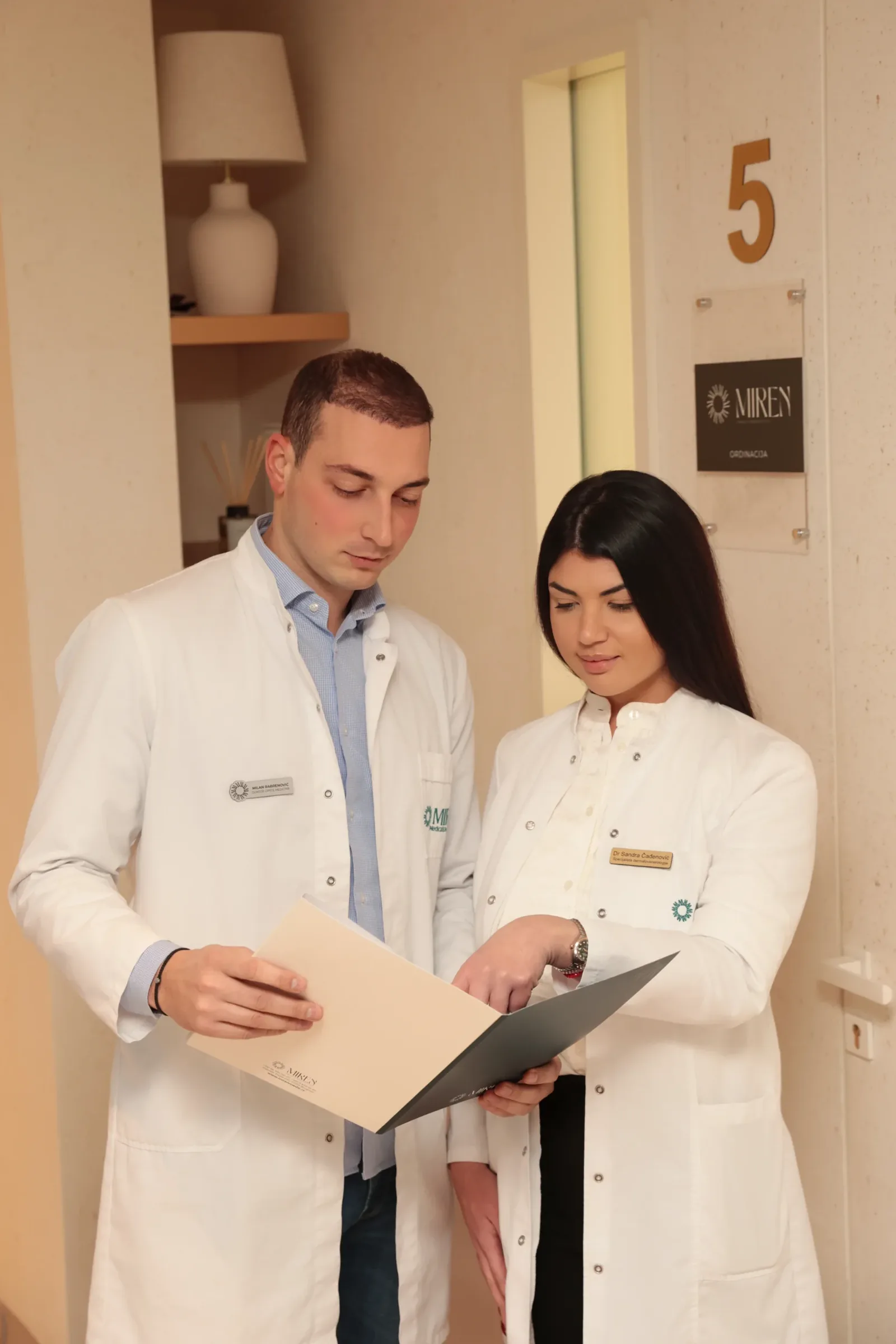 Two Miren Medic polyclinic doctors in white coats reviewing medical documentation