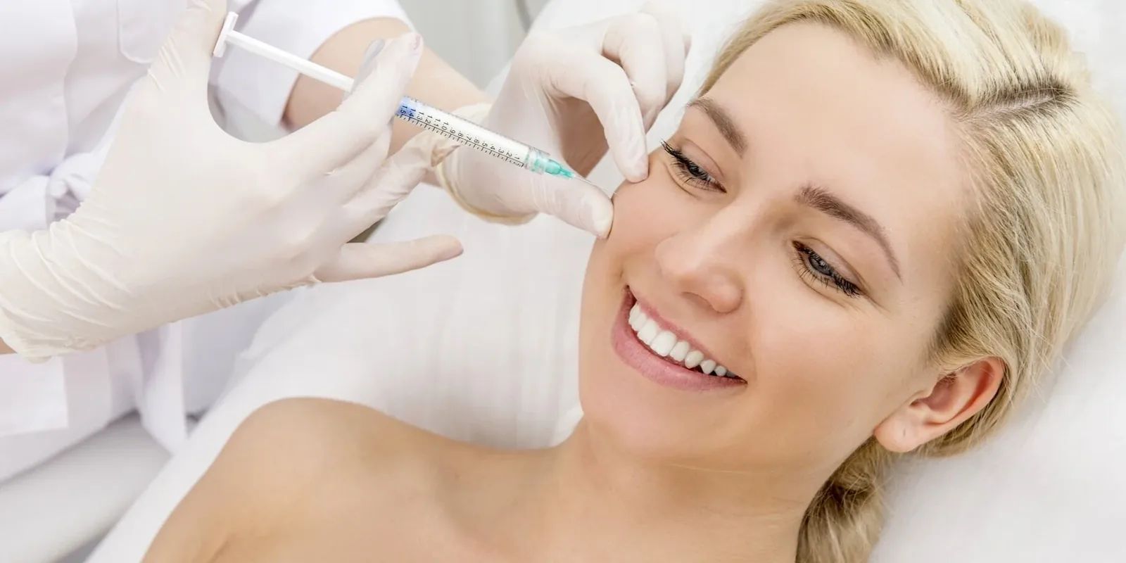 Smiling patient receiving an injectable anti-aging facial treatment at the Mirenmedic clinic.