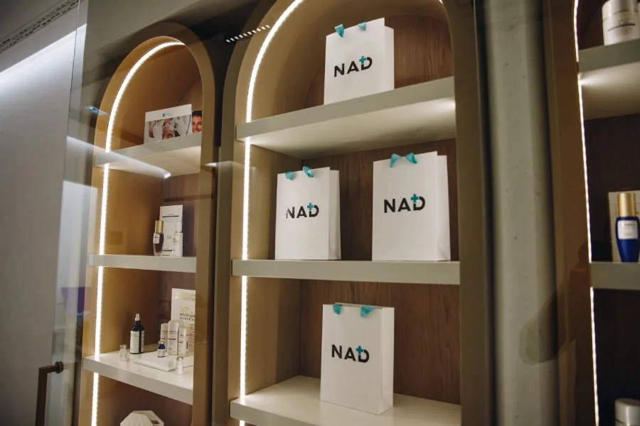 Lit display shelves with NAD+ bags and skincare products: Miren Medic gallery