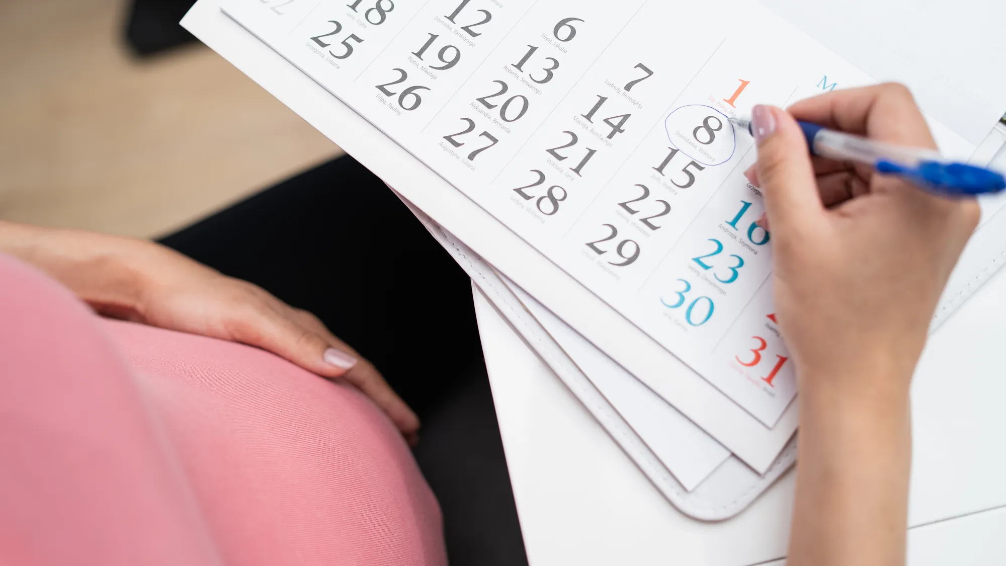 Pregnant woman marking her due date on a calendar
