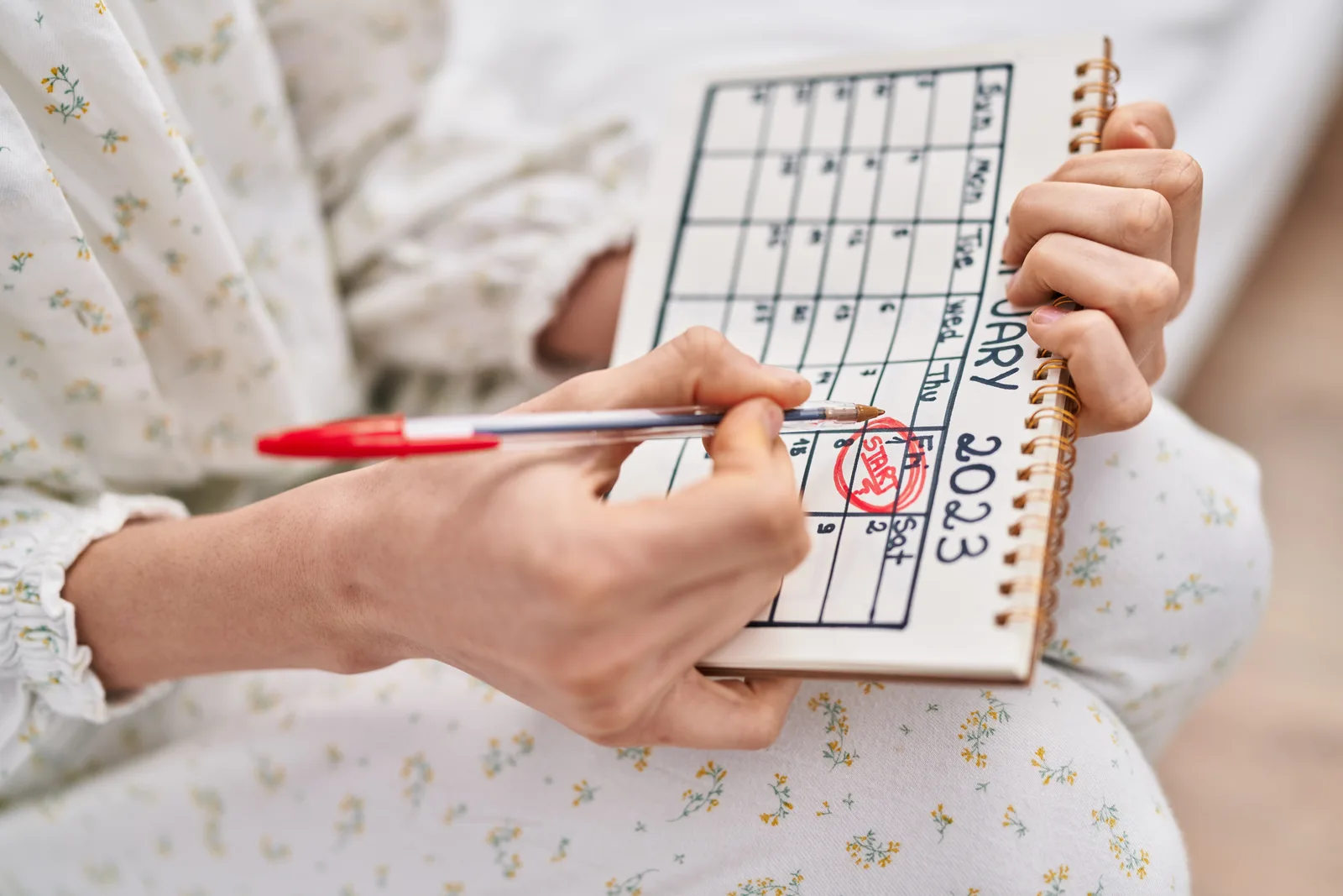 Woman marking dates on a calendar to track her menstrual cycle